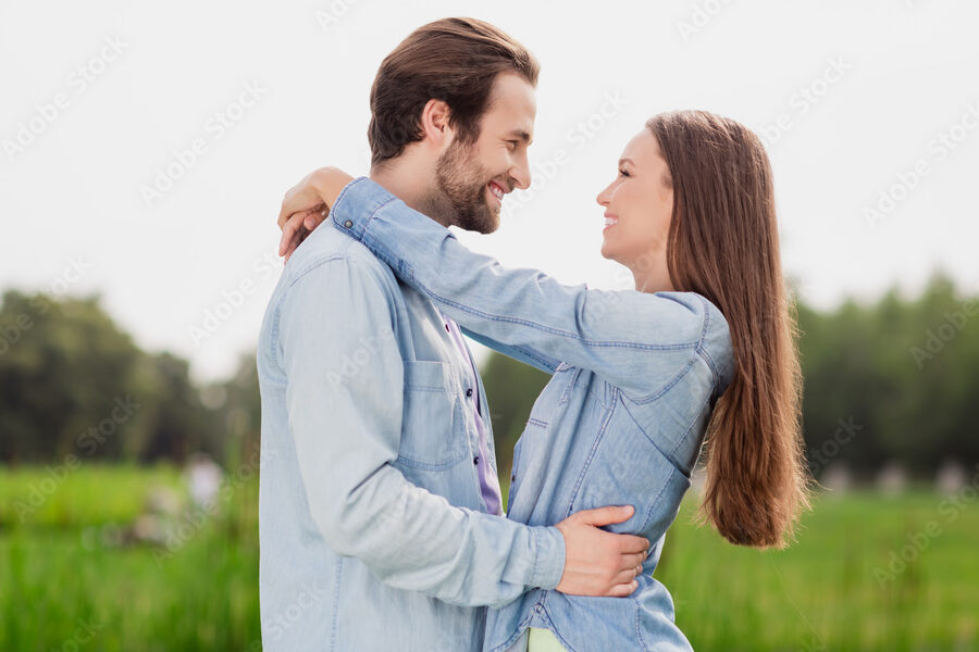 dos personas sonrientes abrazandose en un parque