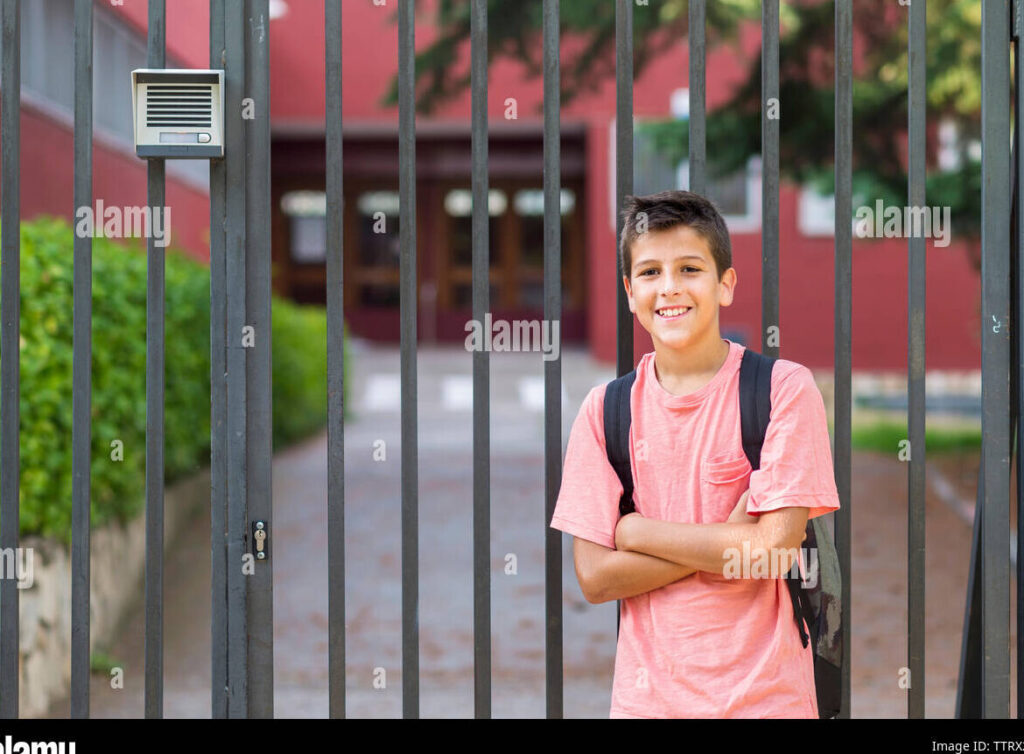 una foto de un estudiante sonriendo mientras se dirige a la puerta de una escuela secundaria