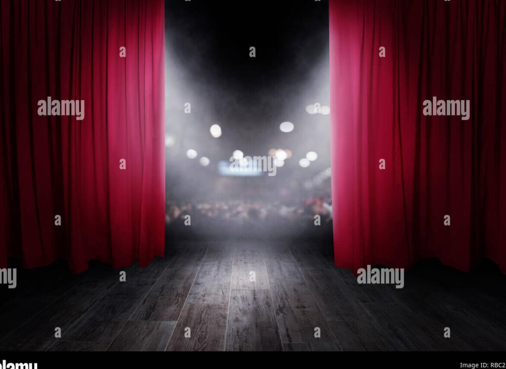 una foto de un grupo de ratones en un escenario de teatro con luces brillantes y una cortina roja de fondo
