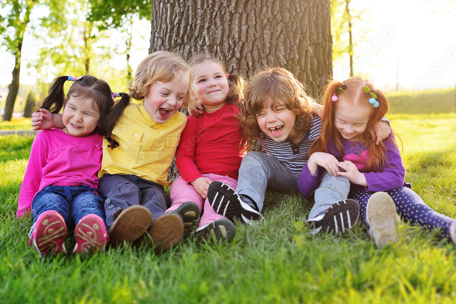 una imagen colorida de un grupo de ninos riendo y jugando al aire libre