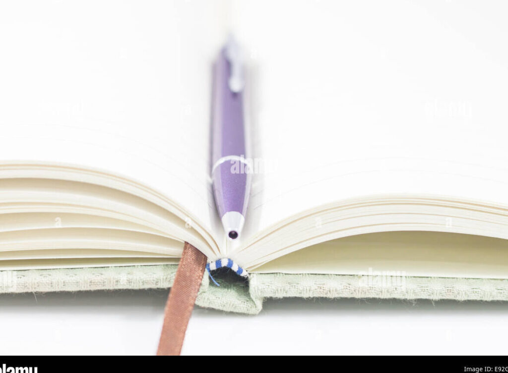 una imagen de un libro abierto con un lapiz y cuaderno al lado