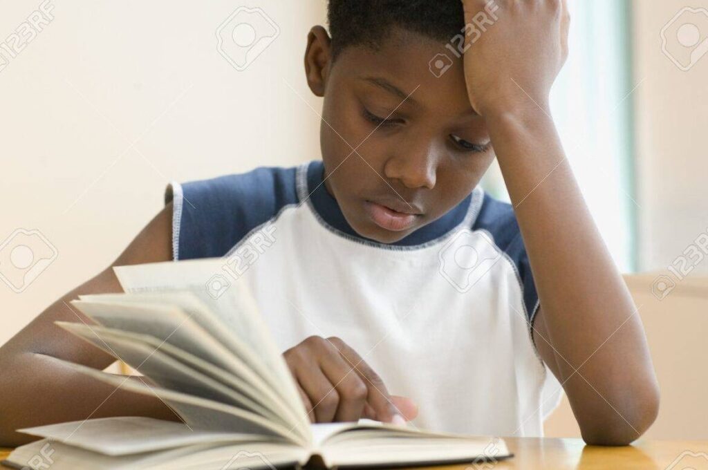 una imagen de un nino leyendo un libro con concentracion