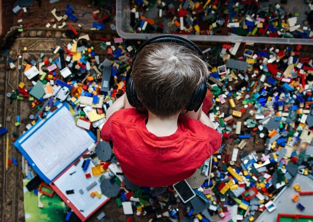 una imagen de un nino pequeno rodeado de libros y juguetes coloridos