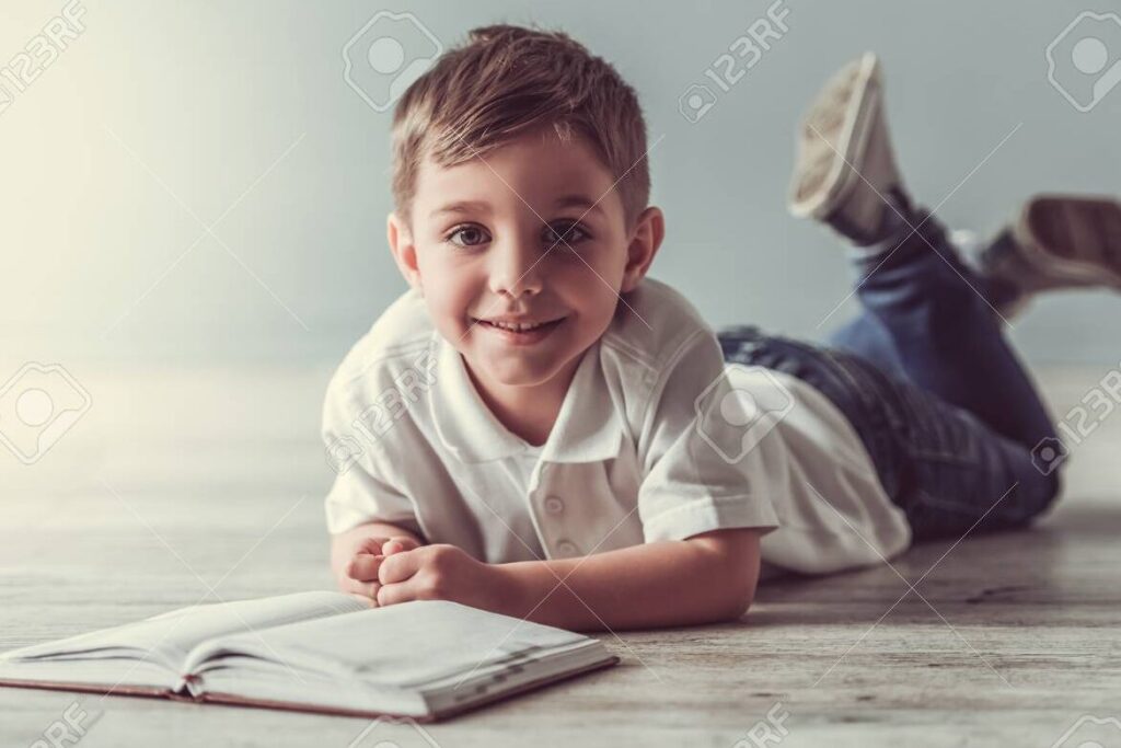 una imagen de un nino sonriendo mientras lee un libro rapidamente