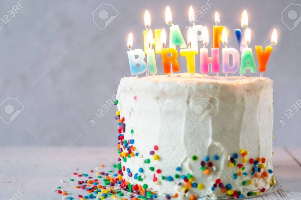 una imagen de un pastel de cumpleanos con velas y decoraciones coloridas