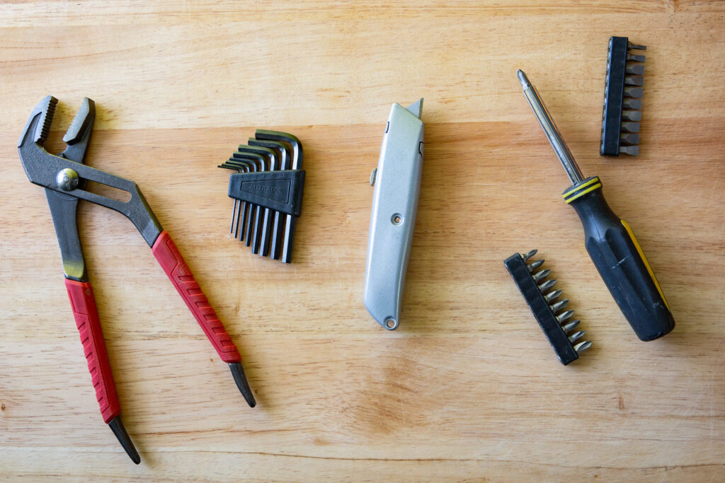 una imagen de un sapo de bano con una llave inglesa y herramientas de reparacion alrededor