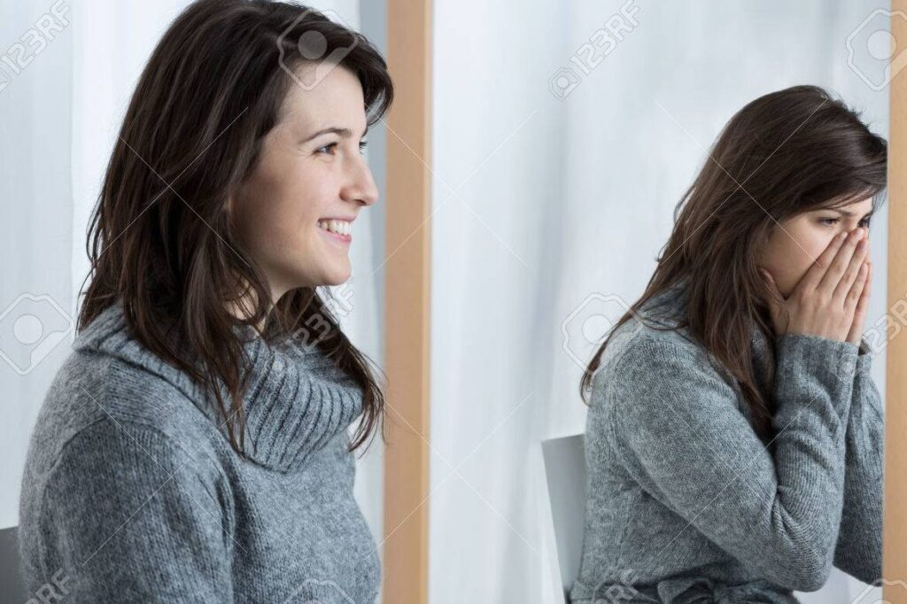 una mujer mirando su reflejo en el espejo y sonriendo