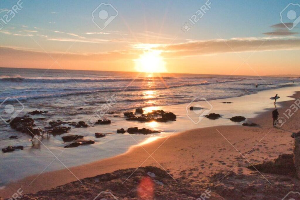 una puesta de sol en la playa con colores calidos y tranquilos